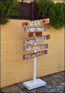 a sign that says with sandy toes and salty kisses we becomerr andms at La Luna Apartments in Stalís