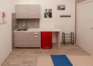 eine Küche mit einem roten Kühlschrank neben einer Theke in der Unterkunft Carramba! Che Room in Cagliari