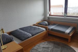 two twin beds in a room with a window at Ferienwohnung König in Dornstadt