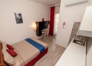 a small bedroom with a bed and a television at Carramba! Che Room in Cagliari