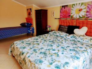 una camera da letto con un letto con copriletto floreale di Deliziosa casetta in centro a 10 min dal mare a Teulada