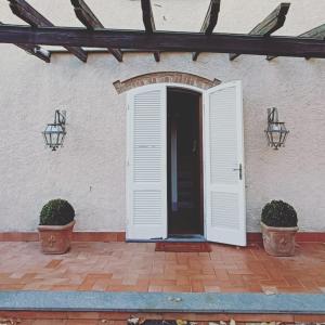 an open door of a house with two pots at Villa Marinsky Pietrasanta , Lucca in Pietrasanta