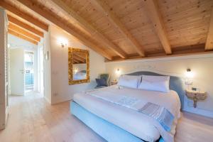 a bedroom with a large bed and a wooden ceiling at Attico con vista sul lago e montagne a Molveno in Molveno