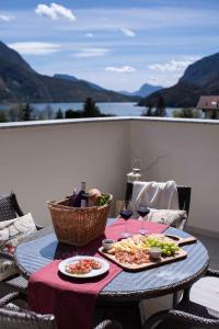 un tavolo con due piatti di cibo su un patio di Attico con vista sul lago e montagne a Molveno a Molveno