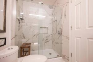 a white bathroom with a shower and a toilet at The Creekside Retreat: Steps to all of Telluride in Telluride