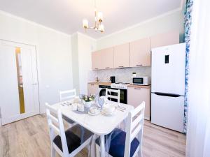 アスタナにあるWelcome to Asyl Muraの白いキッチン(テーブル、白い冷蔵庫付) +15枚の写真