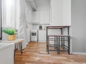 a kitchen with white cabinets and two bar stools at Residential Homes Franzén in Helsinki