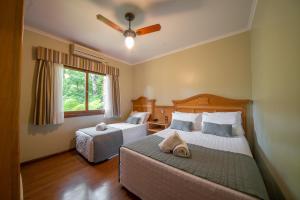 a bedroom with two beds and a window at Pousada Monte Felice Recanto da Lua in Gramado