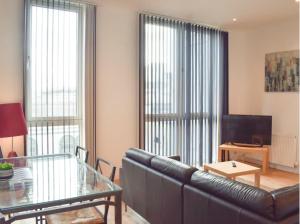 a living room with a leather couch and a glass table at Modern 2BD2Bath Apart CityCentre in Glasgow