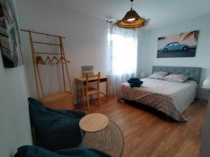 sypialnia z łóżkiem i stołem w obiekcie Maison et parking privé proche zénith et volcans. w mieście Le Cendre