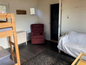 Un dormitorio con una silla roja y una cama en Lycke - By the sea, en Lycke