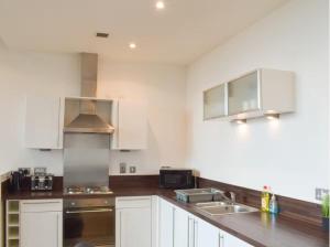 a kitchen with white cabinets and stainless steel appliances at Modern 2BD2Bath Apart CityCentre in Glasgow