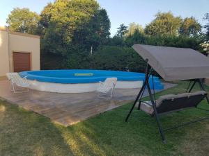 a pool with a table and chairs and an umbrella at BAHIA BLANCA-BARRIO PARQUE in Bahía Blanca