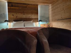 a bedroom with a bed with two chairs in it at Chambre Trèfle in Entremont