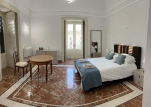 a bedroom with a bed and a desk and a table at Appartamento “Al Duomo” Catania in Catania