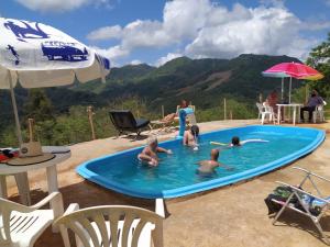 a group of people playing in a swimming pool at CHÁCARA DOMINGOS MARTINS - SANTO GRAAL - Montanhas, Corredeiras, Piscina, Natureza e Paz in Domingos Martins