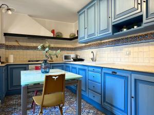 a kitchen with blue cabinets and a table and a sink at Appartamento “Al Duomo” Catania in Catania
