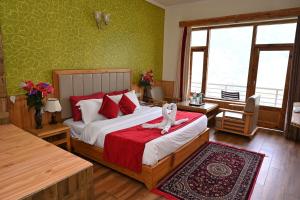 Hotel Seven Hills Manali في مانالي: غرفة نوم عليها سرير وفوط