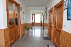 a hallway with wooden doors and a hallway with a plant at Hotel Seven Hills Manali in Manāli