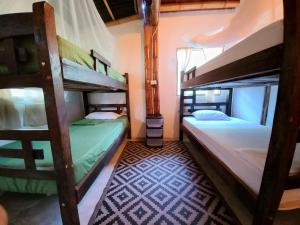 a room with two bunk beds in a house at Casa Estuario in Buritaca