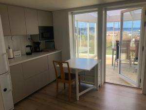 a kitchen with a white table and a table and chairs at Lycke - By the sea in Lycke