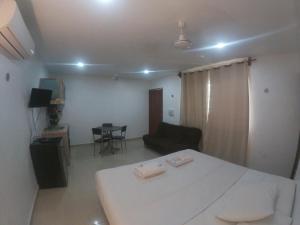 a room with a bed and a couch and a table at Villas Karalv in Bacalar