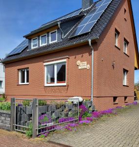 uma casa de tijolos vermelhos com painéis solares no telhado em Biene's Bärenstube em Elze