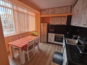 y cocina con mesa, sillas y nevera. en Апартамент за нощувка, център!, en Stara Zagora