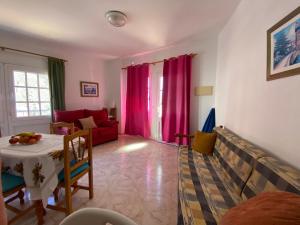 a living room with a table and a red couch at Casa Ramón in Calera