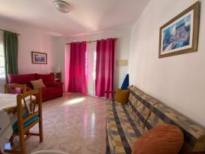 sala de estar con sofá rojo y cortinas rosas en Casa Ramón, en Calera