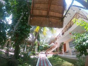 a courtyard of a house with trees and a walkway at Villas Karalv in Bacalar