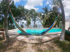 a hammock hanging between two trees next to a swimming pool at Villas Karalv in Bacalar