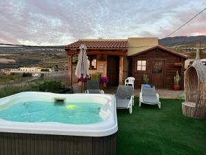 una bañera de hidromasaje en un césped junto a una casa en La Cabaña en Guía de Isora