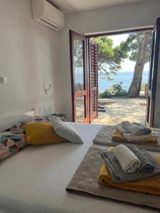 a bedroom with two beds with a view of the ocean at Apartman Zlatan in Sveta Nedelja