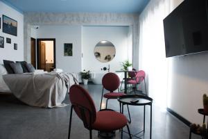 a bedroom with a bed and chairs and a television at Le Terrazze del Duca San Pietro Guesthouse in Rome