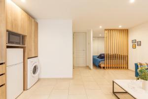 a living room with a washing machine and a bedroom at le Roche in Toulon