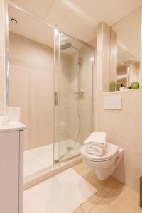a white bathroom with a shower and a toilet at le Roche in Toulon