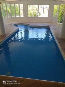 a swimming pool with blue water in a house at Mediterráneo Cabañas in Chascomús