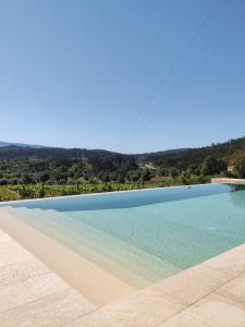 a swimming pool with a view of the water at Quinta Dona Iria in Miranda do Corvo