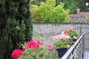 una pared de ladrillo con flores en una valla en Cora Hotels Leon d'Oro en CastellʼArquato