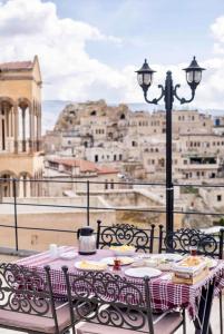 - une table avec des assiettes de nourriture et une vue sur la ville dans l'établissement Uzay Cave Suite Hotel, à Ürgüp