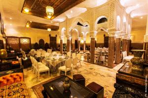 una grande sala banchetti con tavoli e sedie bianchi di Riad Ritaj a Meknès