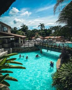 a group of people swimming in a swimming pool at Suíte caldas novas (Risorte) in Caldas Novas