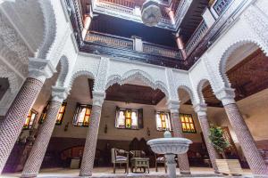 a lobby with a fountain in the middle of a building at Riad Ritaj in Meknès