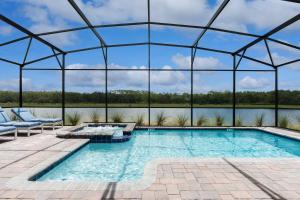 uma piscina interior com telhado de vidro e um pátio em Lakeview Villas in Storey Lake Resort by Diamond Vacation Homes em Kissimmee