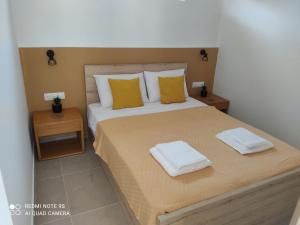 a bedroom with a large bed with yellow pillows at Studio Evridiki in Georgioupolis