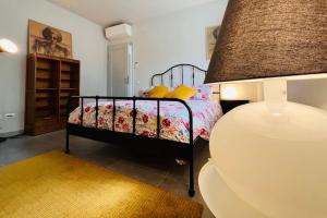 a small bedroom with a bed and a lamp at Appartamento 109 con giardino esclusivo in Lucca
