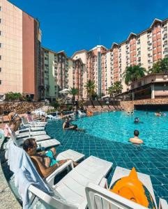 a group of people sitting in chairs in a swimming pool at Suíte caldas novas (Risorte) in Caldas Novas