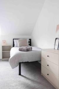 a white bedroom with a bed and a dresser at Charming 3 bedroom Belfast townhouse in Belfast