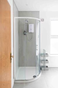 a shower with a glass door in a bathroom at Charming 3 bedroom Belfast townhouse in Belfast